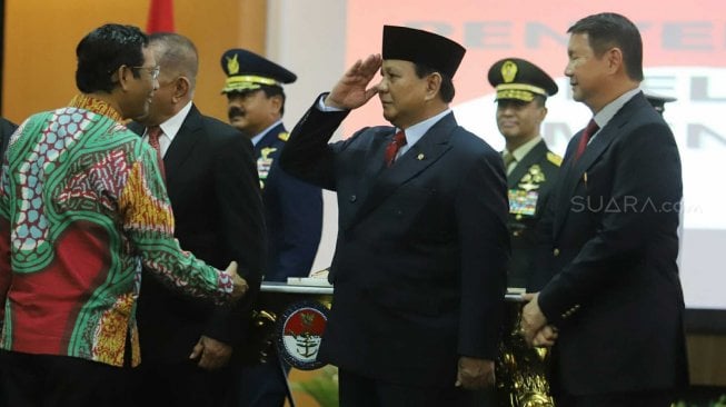 Menteri Pertahanan Prabowo Subianto hormat ke Menkopolhukam Mahfud MD saat acara penyerahan memorandum pelaksana tugas Menteri Pertahanan di Kementerian Pertahanan, Jakarta, Kamis (24/10). [Suara.com/Arya Manggala]