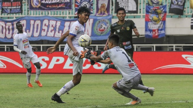 Penjaga gawang Tira Persikabo Angga Saputro (kanan) menangkap bola yang ditendang pesepak bola Arema FC Jayus Hariono (kedua kiri) pada lanjutan Liga 1 2019 di Stadion Pakansari, Cibinong, Bogor, Jawa Barat, Kamis (24/10/2019). Pertandingan tersebut berakhir imbang dengan skor 1-1. ANTARA FOTO/Asprilla Dwi Adha/wsj.