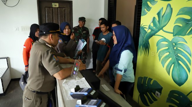 Petugas Satpol PP melakukan pendataan izin penginapan berbasis aplikasi dan rumah kos di kawasan Palmerah, Jakarta, Jumat (25/10). [Suara.com/Arya Manggala]