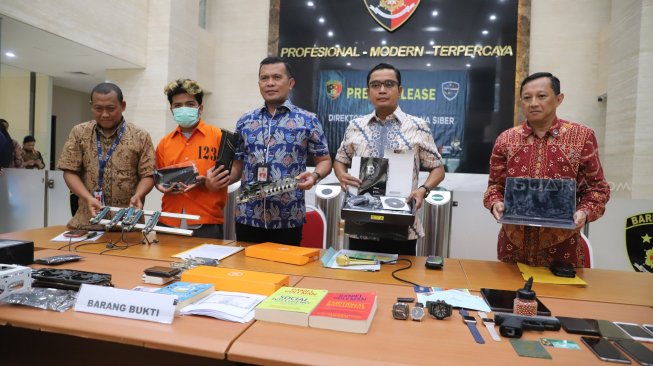 Kasubdit II Direktorat Tindak Pidana Siber Bareskrim Polri Kombes Pol Rickynaldo Chairul (tengah) menunjukkan tersangka dan barang bukti saat pengungkapan penyebar ransomware di Mabes Polri, Jakarta, Jumat (25/10). [Suara.com/Arya Manggala]