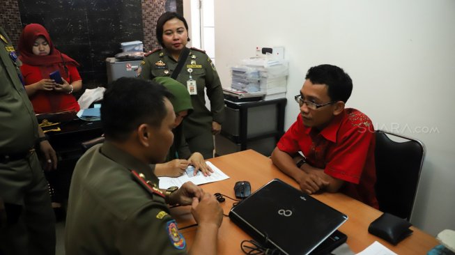 Petugas Satpol PP melakukan pendataan izin penginapan berbasis aplikasi dan rumah kos di kawasan Palmerah, Jakarta, Jumat (25/10). [Suara.com/Arya Manggala]