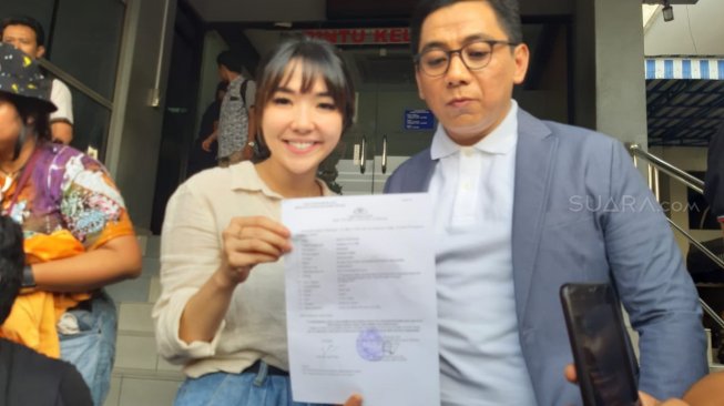 Gisella Anastasia dan pengacara, Sandy Arifin menunjukkan surat laporan kasus video porno di Polda Metro Jaya, Jumat (25/10/2019). [Sumarni/Suara.com]