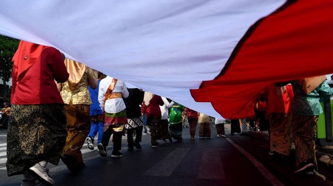 Sejumlah pelajar membentangkan bendera Merah Putih saat digelar Upacara Sumpah Merah Putih dalam rangka peringatan Hari Sumpah Pemuda di lapangan Tugu Pahlawan, Surabaya, Jawa Timur, Sabtu (26/10). [ANTARA FOTO/Zabur Karuru]