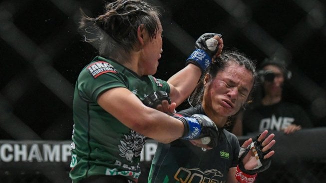 Petarung asal Indonesia Priscilla Hertati Lumban Gaol (kanan) terkena pukulan lawannya petarung asal Myanmar Bozhena Antoniyar (kiri) dalam laga ONE Championship-Dawn of Valor kelas Atom (Atomweight) di Istora Senayan, Jakarta, Jumat (25/10). [ANTARA FOTO/M Risyal Hidayat]