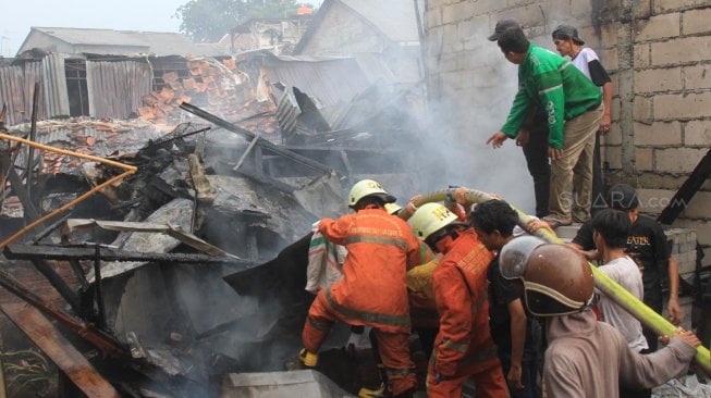 Petugas Pemadam Kebakaran memadamkan rumah yang terbakar di Jalan Anyer, Jakarta, Sabtu (26/10). [Suara.com/Oke Atmaja]