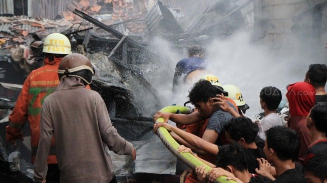 Petugas Pemadam Kebakaran memadamkan rumah yang terbakar di Jalan Anyer, Jakarta, Sabtu (26/10). [Suara.com/Oke Atmaja]