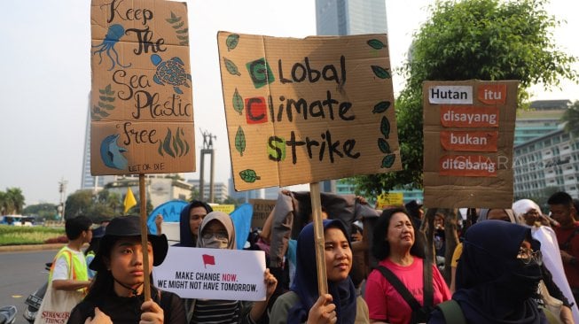 Aktivis dari berbagai organisasi lingkungan berjalan menuju Taman Aspirasi Monas saat aksi terkait krisis iklim di Kawasan Bundaran HI, Jakarta, Sabtu (26/10). [Suara.com/Arya Manggala]