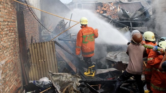 Petugas Pemadam Kebakaran memadamkan rumah yang terbakar di Jalan Anyer, Jakarta, Sabtu (26/10). [Suara.com/Oke Atmaja]