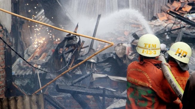 Petugas Pemadam Kebakaran memadamkan rumah yang terbakar di Jalan Anyer, Jakarta, Sabtu (26/10). [Suara.com/Oke Atmaja]