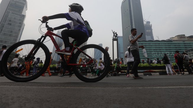 Warga beraktivitas di area 'car free day' (CFD) di kawasan Bundaran Hotel Indonesia, Jakarta, Minggu (27/10). [Suara.com/Angga Budhiyanto]