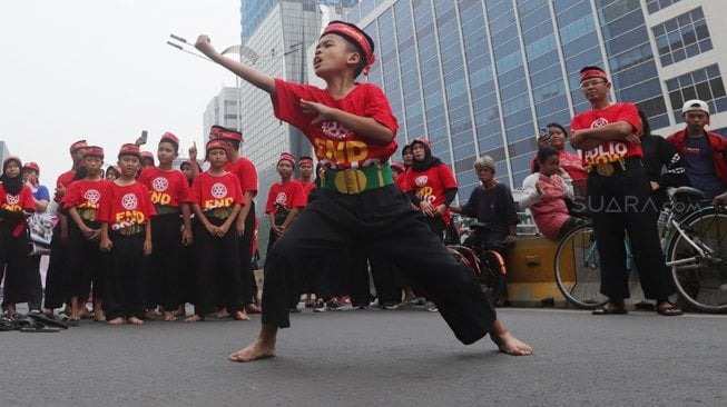 Atraksi pencak silat saat kampanye basmi penyakit polio di area 'car free day' (CFD) Bundaran Hotel Indonesia, Jakarta, Minggu (27/10). [Suara.com/Angga Budhiyanto]