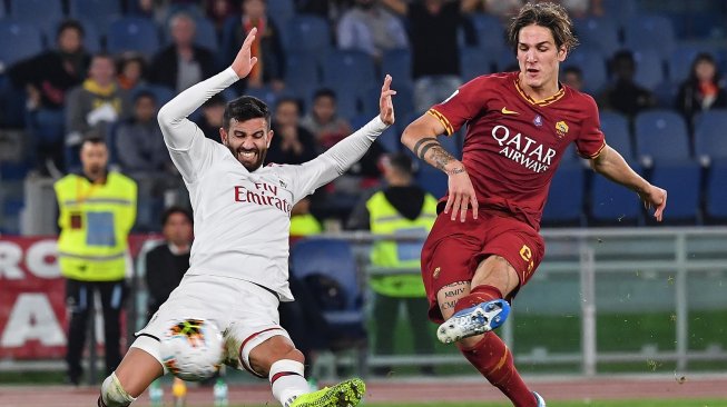 Gelandang AS Roma Nicolo Zaniolo menendang bola melewati bek AC Milan Mateo Musacchio selama pertandingan sepak bola Serie A Italia antara AS Roma melawan AC Milan di Stadion Olimpico, Roma, Italia, Senin (28/10). [Andreas SOLARO / AFP]