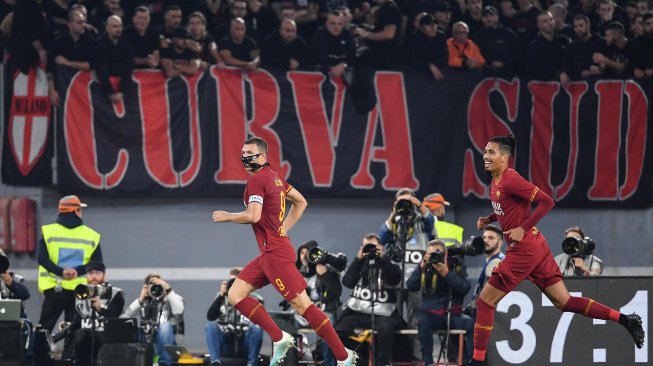 Pemain depan AS Roma Edin Dzeko merayakan golnya setelah mencetak gol ke gawang AC Milan selama pertandingan sepak bola Serie A Italia antara AS Roma melawan AC Milan di Stadion Olimpico, Roma, Italia, Senin (28/10). dini hari WIB. [Andreas SOLARO / AFP]