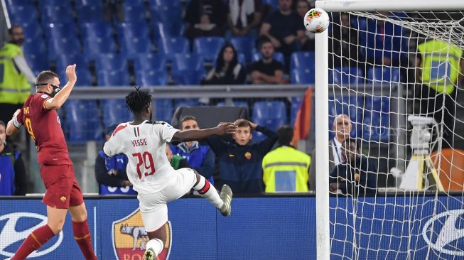 Pemain depan AS Roma Edin Dzeko (kiri) menembak dan mencetak gol selama pertandingan sepak bola Serie A Italia antara AS Roma melawan AC Milan di Stadion Olimpico, Roma, Italia, Senin (28/10). dini hari WIB. [Andreas SOLARO / AFP]