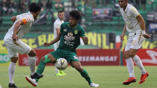 Pesepak bola Persebaya Muhammad Hidayat (tengah) berebut bola dengan pesepak bola PSS Sleman Mohammad Bagus Nirwanto (kiri) saat pertandingan Liga 1 2019 di Stadion Gelora Bung Tomo, Surabaya, Jawa Timur, Selasa (29/10/2019). Persebaya kalah melawan PSS Sleman dengan skor akhir 2-3. ANTARA FOTO/Moch Asim/pd.