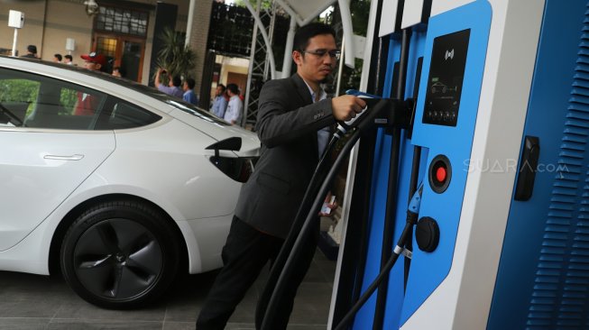 Pengemudi mengisi baterai kendaraan listrik di SPKLU PLN Unit Induk Distribusi Jakarta, Selasa (29/10).  [Suara.com/Arya Manggala]