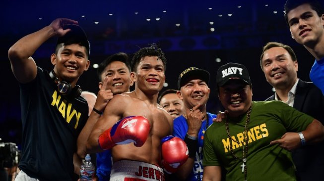 Petinju Filipina, Jerwin Ancajas, merayakan keberhasilannya pertahankan sabuk juara dunia kelas bantam junior IBF bersama timnya usai mengalahkan Ryuichi Funai (Jepang) di  Stockton Arena, California, AS, Sabtu (4/5/2019). [AFP/Frederic J. Brown]