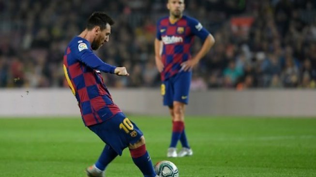 Aksi Lionel Messi saat mencetak gol kewat tendangan bebas ke gawang Real Valladolid dalam lanjutan La Liga Spanyol, Rabu (30/10/2019) dini hari WIB. (LLUIS GENE / AFP)