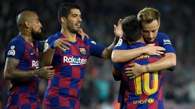 Lionel Messi merayakan gol bersama rekan setimnya usai mencetak tendangan bebas indah saat menjamu Real Valladolid di Camp Nou, Rabu (30/10/2019). (AFP)