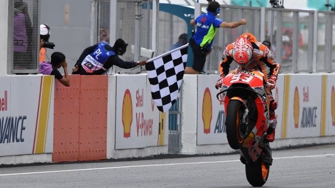 Pebalap Repsol Honda, Marc Marquez, melintasi garis finis pertama pada balapan MotoGP Malaysia 2018 di Sirkuit Sepang, Minggu (4/11). [AFP/Mohd Rasfan]