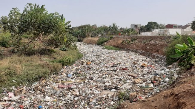 Sampah mengular di Kali Jambe Kabupaten Bekasi Jawa Barat. [Suara.com/M Yacub]