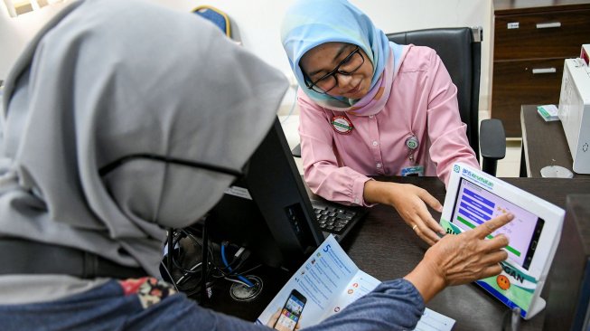 Pegawai melayani warga di kantor Badan Penyelenggara Jaminan Sosial (BPJS) Kesehatan Jakarta Timur, di Jakarta, Rabu (30/10). [ANTARA FOTO/M Risyal Hidayat]