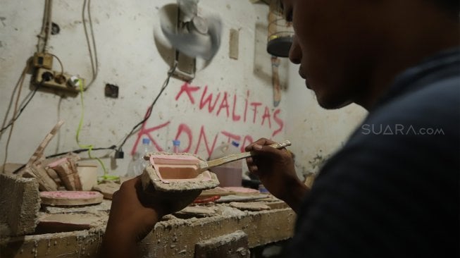 Pekerja menyelesaikan pembuatan plakat wayang dan garuda di Industri Rumahan Pluit, Penjaringan, Jakarta Utara, Rabu (30/10). [Suara.com/Angga Budhiyanto]
