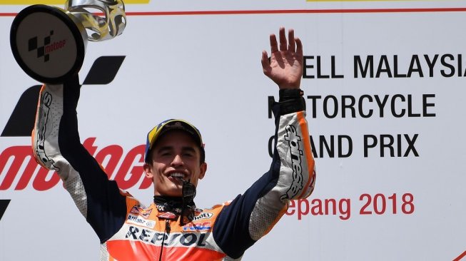 Pebalap Repsol Honda, Marc Marquez, merayakan keberhasilan meraih podium pertama MotoGP Malaysia 2018 di Sirkuit Sepang, Minggu (4/11). [AFP/Mohd Rasfan]