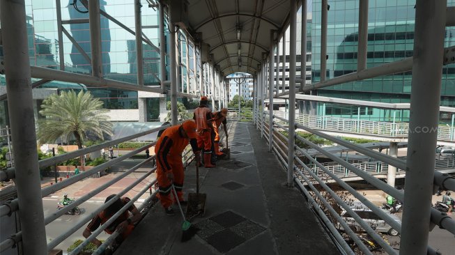 
Petugas Kebersihan membersihkan jembatan penyeberangan orang (JPO) yang tidak terawat dan menimbulkan bau pesing di kawasan Karet Kuningan, Jakarta, Rabu (30/10). [Suara.com/Angga Budhiyanto]