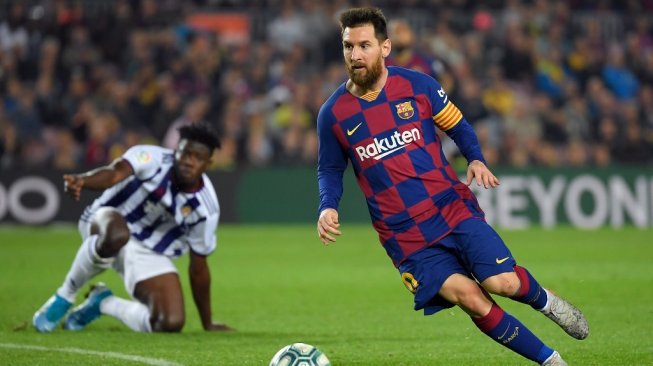 Penyerang Barcelona, Lionel Messi sukses melewati pemain Real Valladolid pada Liga Spanyol 2019/20 di Stadion Camp Nou, Rabu (30/10/2019). [LLUIS GENE / AFP]