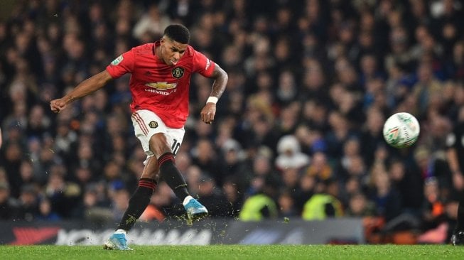 Penyerang Manchester United, Marcus Rashford menendang bola pada laga Piala Liga Inggris 2019/2020 kontra Chelsea di Stamford Bridge, London, Kamis (31/10/2019) dini hari WIB. [Glyn KIRK / AFP]