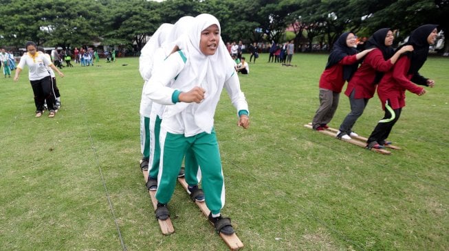 Pelajar mengikuti lomba permainan tradisional terompah panjang di lapangan Blangpadang, Banda Aceh, Aceh, Sabtu (2/11). [ANTARA FOTO/Irwansyah Putra]