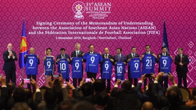 Presiden Joko Widodo (ketiga kanan) bersama kepala negara dan kepala pemerintahan negara-negara ASEAN menunjukkan kaos sepak bola (jersey) bertuliskan namanya masing-masing disaksikan Presiden FIFA Gianni Infantino (kiri) dan Sekjen ASEAN Dato Lim Jock Hoi (kanan) usai menyaksikan penandatanganan Nota Kesepahaman antara FIFA dan ASEAN di Bangkok, Thailand, Sabtu (2/11). [ANTARA FOTO/Akbar Nugroho Gumay]