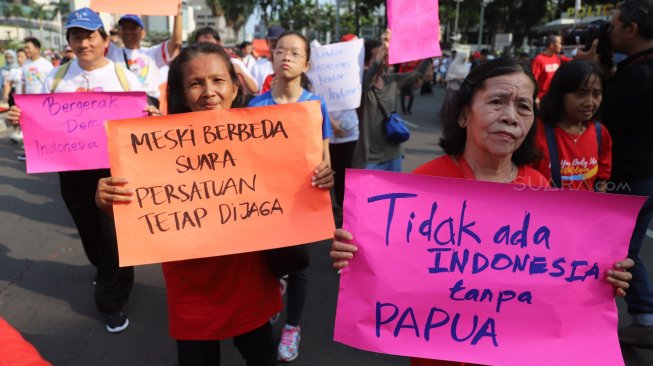 Peserta dari komunitas lintas agama mengikuti gerak jalan di kawasan Hari Bebas Kendaraan Bermotor (HBKB), Jakarta, Minggu (3/11). [Suara.com/Arya Manggala]