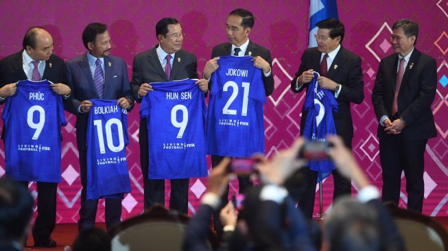 Presiden Joko Widodo (ketiga kanan) bersama kepala negara dan kepala pemerintahan negara-negara ASEAN menunjukkan kaos sepak bola (jersey) bertuliskan namanya masing-masing disaksikan Sekjen ASEAN Dato Lim Jock Hoi (kanan) usai menyaksikan penandatanganan Nota Kesepahaman antara FIFA dan ASEAN di Bangkok, Thailand, Sabtu (2/11). [ANTARA FOTO/Akbar Nugroho Gumay]