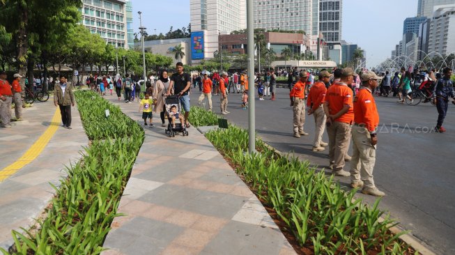 Petugas Satpol PP berjaga di jalur Hari Bebas Kendaraan Bermotor atau Car Free Day, Bundaran HI, Jakarta, Minggu (3/11). [Suara.com/Arya Manggala]