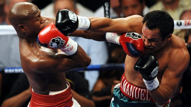 Petinju AS Floyd Mayweather Jr. (kiri) mendaratkan pukulan ke wajah penantangnya Juan Manuel Marquez dalam duel di MGM Grand Garden Arena, Las Vegas, Sabtu (19/9/2009). [AFP/Gabriel Bouys]