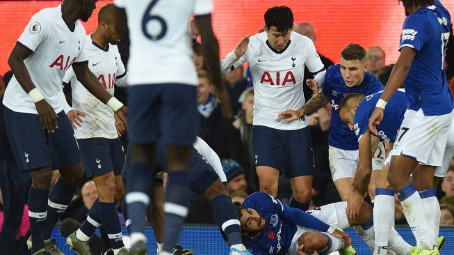 Gelandang Everton André Gomes ditekel striker Tottenham Hotspur Son Heung-min pada pertandingan Liga Inggris di Goodison Park, Liverpool, Inggris, Minggu (3/11). [OLI SCARFF / AFP]