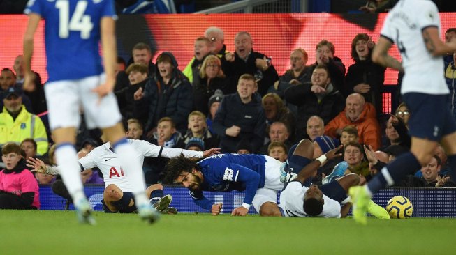 Gelandang Everton André Gomes ditekel striker Tottenham Hotspur Son Heung-min pada pertandingan Liga Inggris di Goodison Park, Liverpool, Inggris, Minggu (3/11). [OLI SCARFF / AFP]