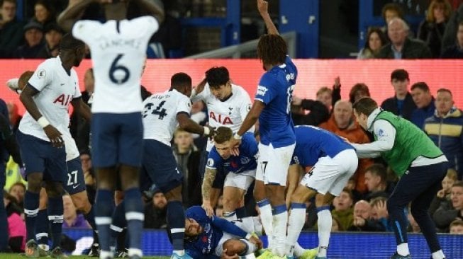 Para pemain Everton mencoba memenangkan rekan setimnya Andre Gomes (tengah) yang mendapatkan cedera patah kaki saat menghadapi Tottenham Hotspur di Goodison Park. Oli SCARFF / AFP