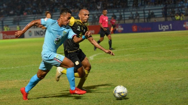 Pemain Persela Sugeng Efendi (kiri) berusaha melewati hadangan pemain Barito Putera Rony Esar (kanan) dalam pertandingan Liga 1 2019 di Stadion Surajaya Lamongan, Jawa Timur, Senin (4/11/2019). Dalam pertandingan itu Persela ditahan imbang Barito Putera dengan skor 0-0. ANTARA FOTO/Syaiful Arif.