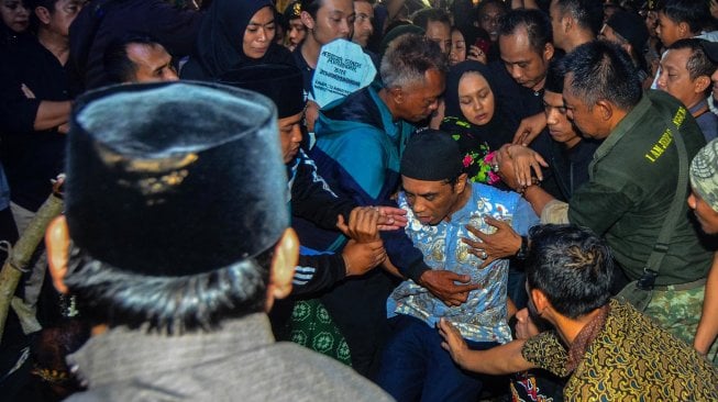 Ayah almarhum Afridza Syach Munandar, Irwan Munandar (48), menangis saat prosesi pemakaman anak sulungnya di pemakaman keluarga kampung Sambong Bencoy, Kota Tasikmalaya, Jawa Barat, Selasa (5/11). [ANTARA FOTO/Adeng Bustomi]