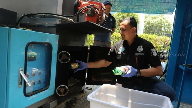 Kasat Resnarkoba Polres Metro Jakarta Barat AKBP Erick Frendriz memusnahkan barang bukti narkoba di Polres Jakarta Barat, Selasa (5/11). [Suara.com/Arya Manggala]