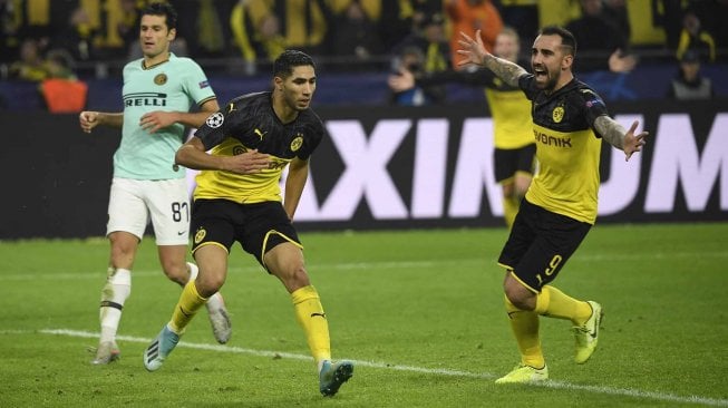 Bek Dortmund Achraf Hakimi merayakan mencetak gol nya  dengan rekan setim dan penggemarnya selama pertandingan sepak bola Grup F Liga Champions antara Borussia Dortmund melawan Inter Milan di Signal Iduna Park, Jerman, Rabu (6/11). dini hari WIB. [INA FASSBENDER / AFP]

