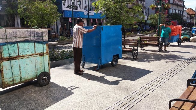 Seorang pedagang baju, Eko Mulyanto, menata lapak daganganya di sisi barat Malioboro, Rabu (6/11/2019). - (SUARA/Baktora)