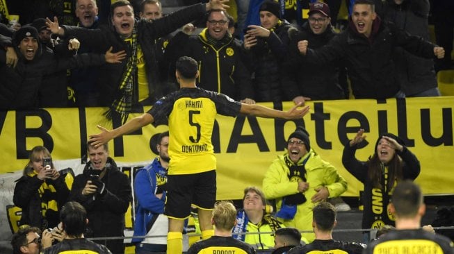 Bek Dortmund Achraf Hakimi merayakan mencetak gol nya  dengan rekan setim dan penggemarnya selama pertandingan sepak bola Grup F Liga Champions antara Borussia Dortmund melawan Inter Milan di Signal Iduna Park, Jerman, Rabu (6/11). dini hari WIB.  [INA FASSBENDER / AFP]