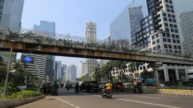 Pejalan kaki melintas di Jembatan Penyeberangan Orang (JPO) tanpa atap di Jalan Sudirman, Jakarta Pusat, Rabu (6/11). [Suara.com/Arya Manggala]