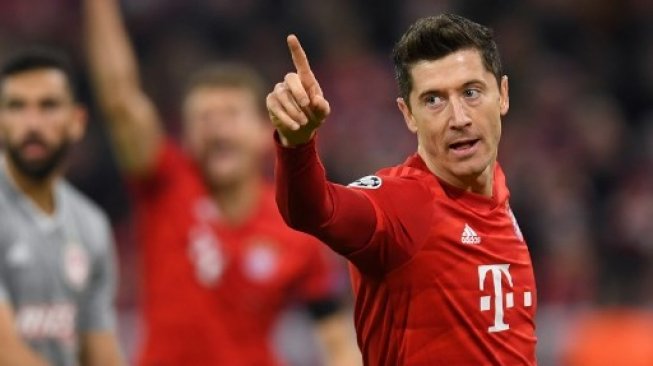 Striker Bayern Munich Robert Lewandowski merayakan golnya ke gawang Olympiakos dalam laga Liga Champions di Munich. Christof STACHE / AFP