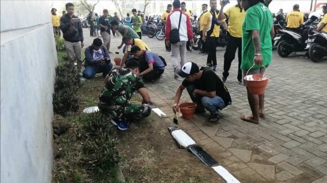 Sejumlah bonek dan TNI menggelar kerja bakti massal di kawasan GBT pada Jumat (8/11/2019). [Suara.com/Arry Saputra]