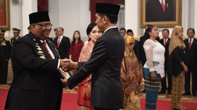 Presiden Joko Widodo (kanan) menyerahkan plakat anugerah gelar pahlawan nasional kepada ahli waris tokoh asal Sulawesi Tenggara Sultan Himayatuddin, Gubernur Sulawesi Tenggara Ali Mazi (kiri) di Istana Negara, Jakarta, Jumat (8/11). [ANTARA FOTO/Puspa Perwitasari]
